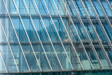 Obraz premium A sleek, modern skyscraper with a grid of reflective glass windows rises sharply into the sky. The concept of backgrounds for business ideas