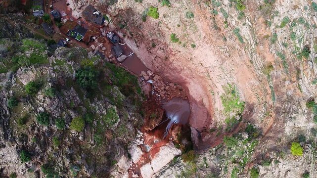 Top-down drone view of the main spring forming the source of the Oum Er-Rbia River in the Middle Atlas near Khenifra, where freshwater emerges from rocky terrain.