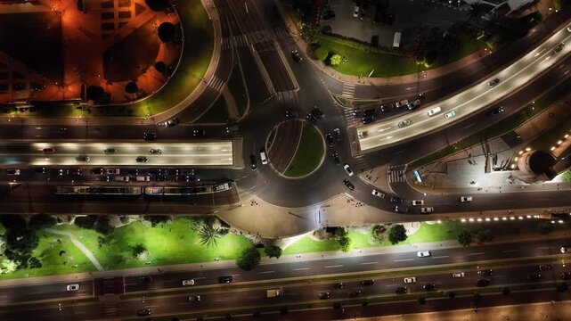 Vertical drone view of a busy illuminated roundabout and multilane roads at night in Rabat, Morocco, showing urban traffic flow and modern city infrastructure.