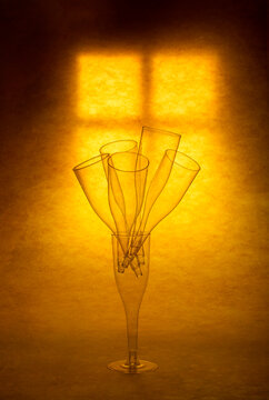 A figure made of glass goblets against a glowing window