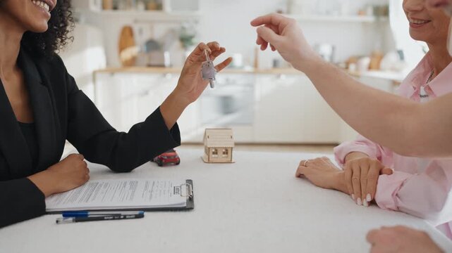 Senior male person taking keys of new house from hands of real estate broker. Sale and buy property, happy people feeling good emotions, dream come true, buy apartments by mortgage and bank credit