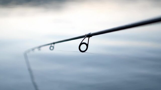 Fishing Rod Tip Quivering 4K - Close-Up Over Water, Anticipation Moment, Soft Light, Angling Hobby - Sport Stock Video
