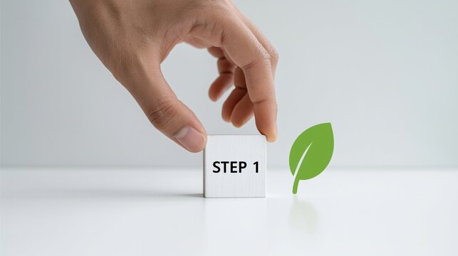 Hand placing a white cube with STEP 1 and a green leaf