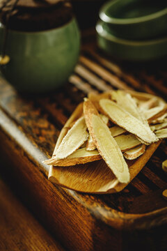 Astragalus root slices on wooden spoon