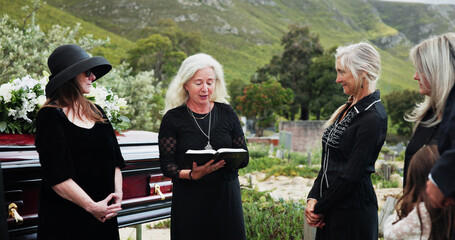 Funeral, old women and pastor with bible at graveyard, religion and memorial service with...