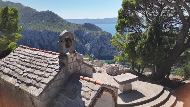 Drone aerial of St Juraj Gradac viewpoint overlooking Omis, mountains and Adriatic coastline.