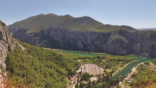 Drone aerial of historic Mila Gojsalic statue overlooking Omis and sea.