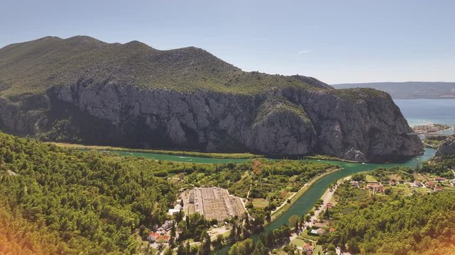 Drone aerial showing Mila Gojsalic statue with panoramic Omis landscape.