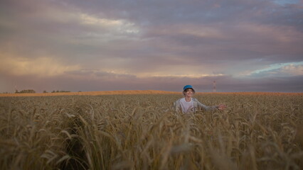 Happy Child Standing in Wheat Field at Sunset, have fun and enjoy