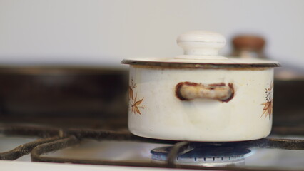 Fototapeta premium Old White Pot Cooking on Gas Stove in Kitchen, have fun and enjoy