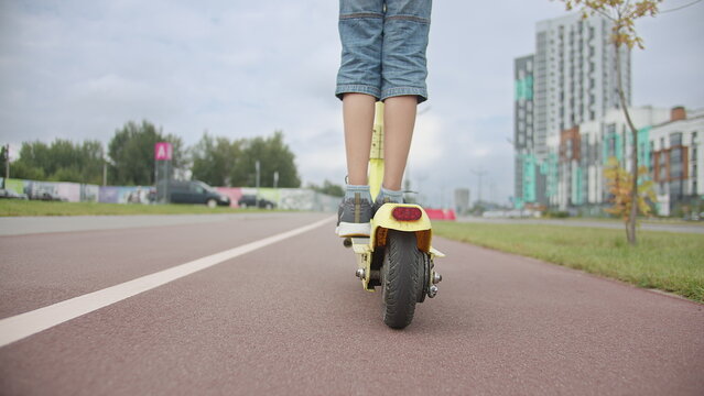 Child Riding Electric Scooter on City Road Outdoors, have fun and enjoy