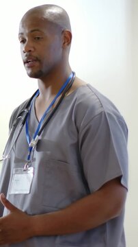 Vertical video: Briefing team, Dr in scrubs gesturing, grabbing phone, steth visible in clinic