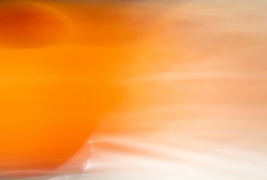 Vibrant orange abstract motion blur background creates a dynamic sense of energy and warmth for creative advertising, web design, and professional presentations.