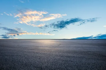 Fototapete Blau Empty asphalt parking lot or race track ground under a clear blue twilight sky.  © ABCDstock