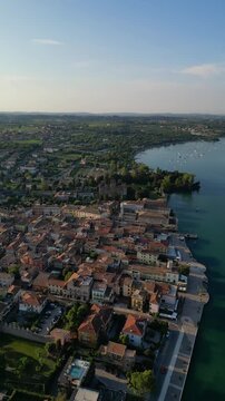 Old port in Lazise town eastern shore of Lake Garda in Italy aerial drone vertical video reel