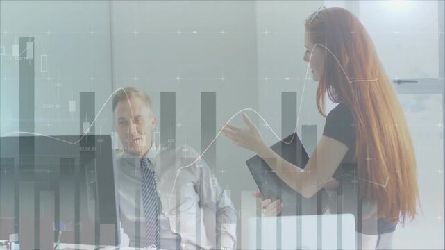 Woman moving closer, showing folder and pointing charts while man leaning, nodding, reviewing data