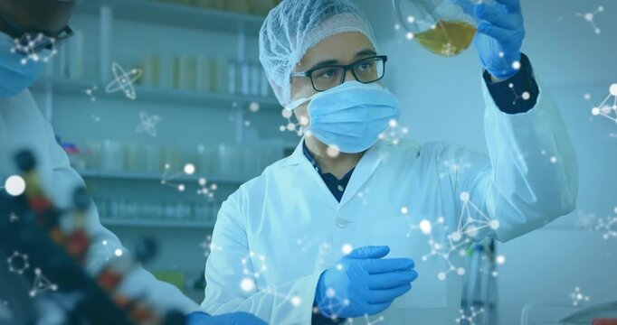 Camera panning, male tech lifting and turning flask, examining and analyzing yellow liquid clarity