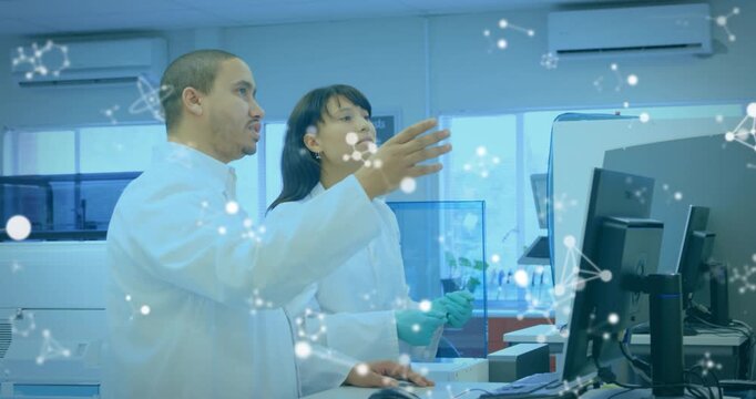 Lab techs clicking mouse and pointing at monitor while molecular overlay showing analyzer results