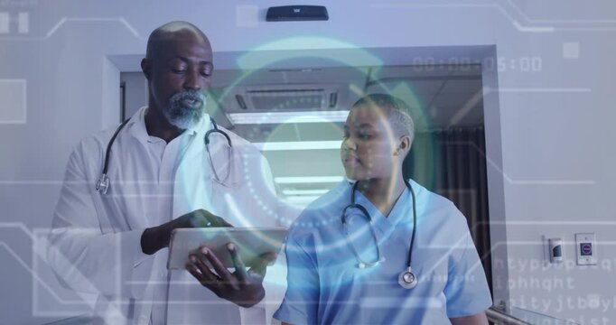 Mature doctor tapping tablet, initiating medical overlay and mentoring nurse while walking corridor