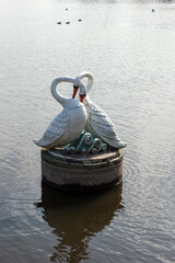 Obraz premium A stunning sculpture of two swans gracefully placed in the river in Brest, Belarus. The piece combines nature and art, making it perfect for showcasing cultural and artistic heritage in urban settings