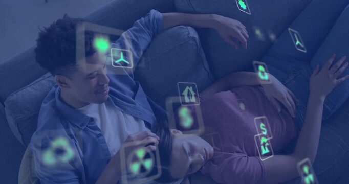 Reclining couple, man in denim stroking woman in mauve top on home sofa, AR icons drifting
