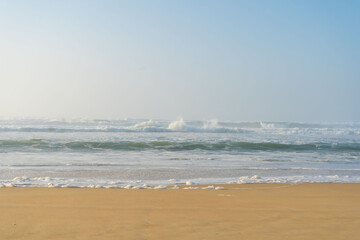Belles vagues avec écume sur la plage de Vieux Boucau sous un soleil voilé © DAUZATS