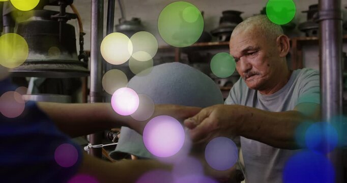 Two technicians positioning helmet and wrapping cord, securing fit in shop, bokeh showing tension