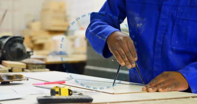 Picking compass carpenter wearing coverall and glasses marking arcs for layout at bench, copy space