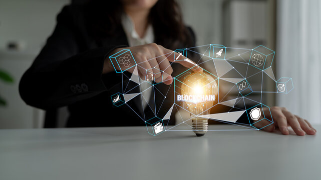 Business Professional Engaging with Innovative Blockchain Technology Concept over Light Bulb in Modern Office Environment Quark.