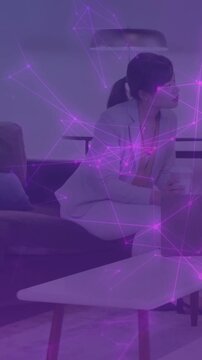 Vertical video: Biz woman reaching box holding cup sipping on break as purple net moving over her