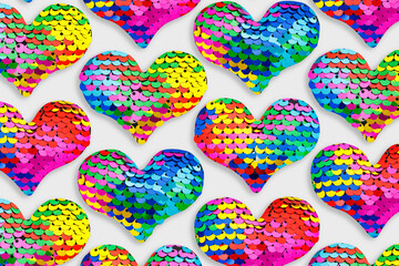 Fototapeta premium Colorful glittering hearts pattern, love symbol of sparkling sequins rainbow colors, trend repeated layout from toys shape heart, creative romance holiday design, festive Valentine designs wallpaper.