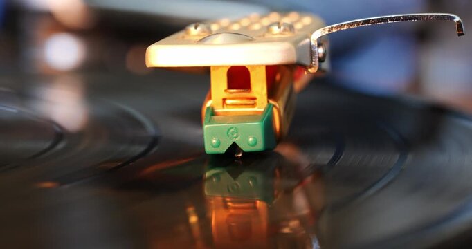 Turntable needle playing a vinyl record. Close up macro shot, front view, real time video, no people