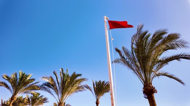 Red flag flies on the beach, symbolizing the rough sea and the ban on bathing.