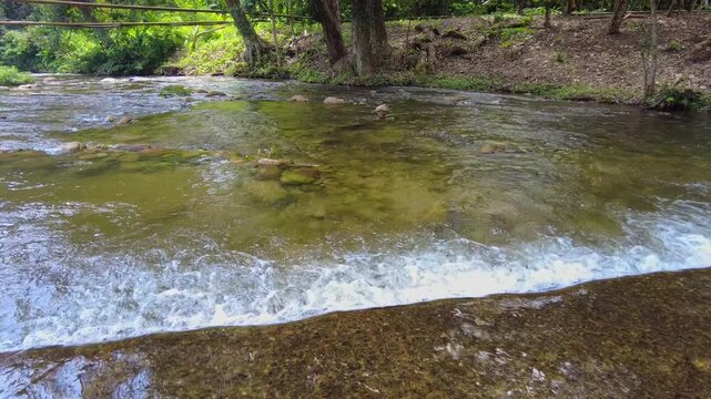 A river flowing across a stretch of road in La Batea, Chuao, Aragua, Venezuela