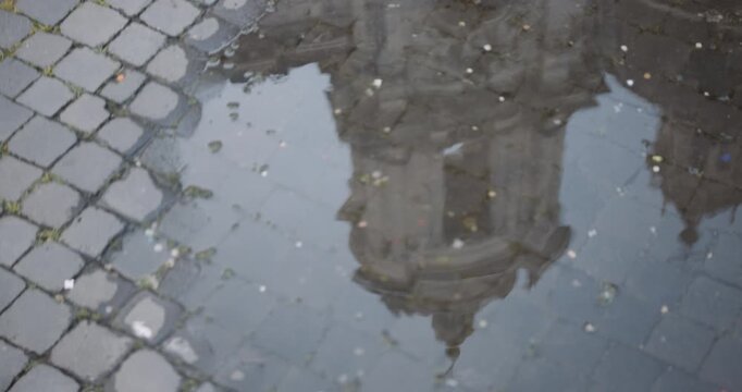 The bell tower of the Church of Sant'Agnese in Agone reflected in a puddle in Piazza Navona, Roma.