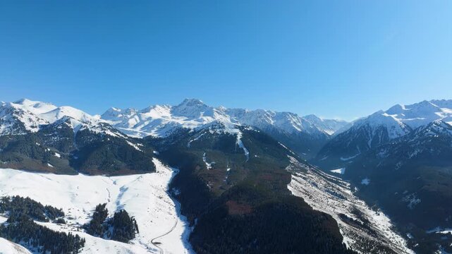 Flying clockwise around distant Karakol Ski Resort peak in early winter.