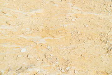 Obraz premium Dry ground covered with light colored stones and small rocks at a construction site in midday sun