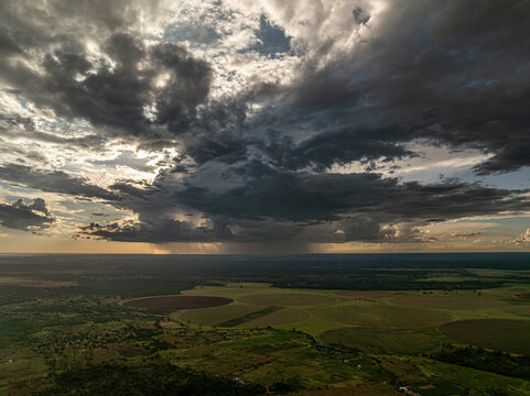 Aerial view of a dramatic sky casting shadows over the lush, green fields and distant horizon, creating a serene yet powerful landscape., Chilanga, Lusaka Province, Zambia.