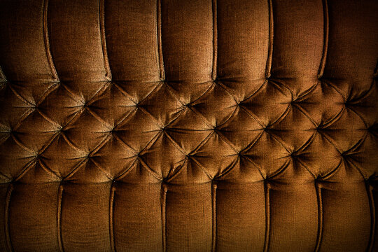 Close-up of brown sofa upholstery. Brown sofa upholstered with Capitone quilting.
