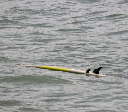 Surfboard lying on sea near the beach