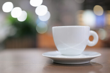 Fototapeta premium White Espresso Cup on Wooden Table with Bokeh Background