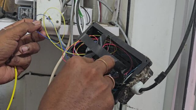 Close-up of a technician performing fiber optic fusion splicing using a precision machine to connect optical cables. The footage highlights high-speed internet infrastructure