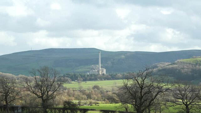 Large chimney of cement factory disrupting rural Peak District landscape