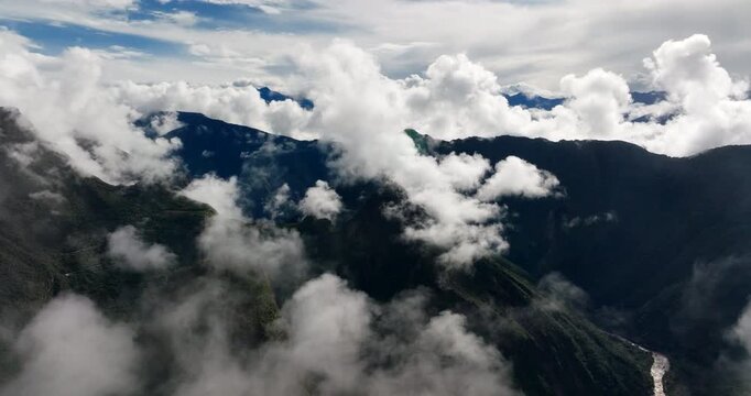 Drone view of the ancient Inca citadel of Machu Picchu revealed through clouds and fog in the Andes mountains, Peru. Aerial, copy space