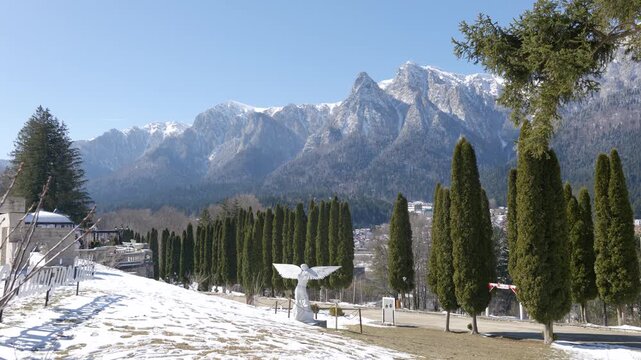 Winter landscape of the snow-covered Bucegi Mountains rising above the town of Busteni, Romania. Scenic Romanian nature and countryside atmosphere.