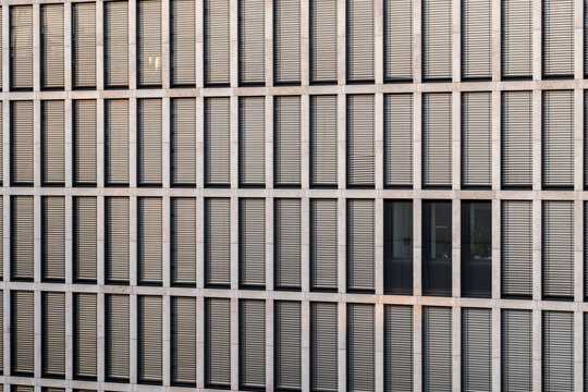 Corporate office facade with windows forming modular grid texture geometry pattern and symmetry in modern architecture background for business