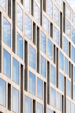 Corporate office facade with windows in strict grid texture geometry pattern and symmetry creating modern architecture background for business use