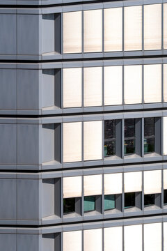 Modern office facade with windows in corporate grid geometry pattern and symmetry creating clean architecture background for business design