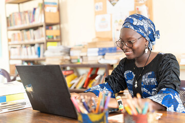 Smiling African student at her laptop in university library © Riccardo Niels Mayer