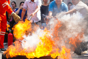 Employees firefighting training, Concept Employees hand using fire extinguisher fighting fire...